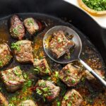 "Garlic butter steak bites in a skillet with herbs"